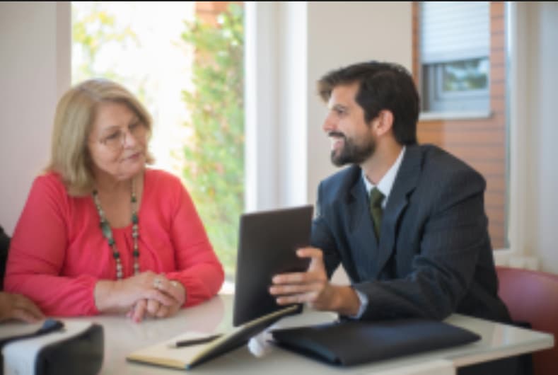 Financial advisor discussing investment options with a senior woman client in a modern office setting.Start Investing Beginner's