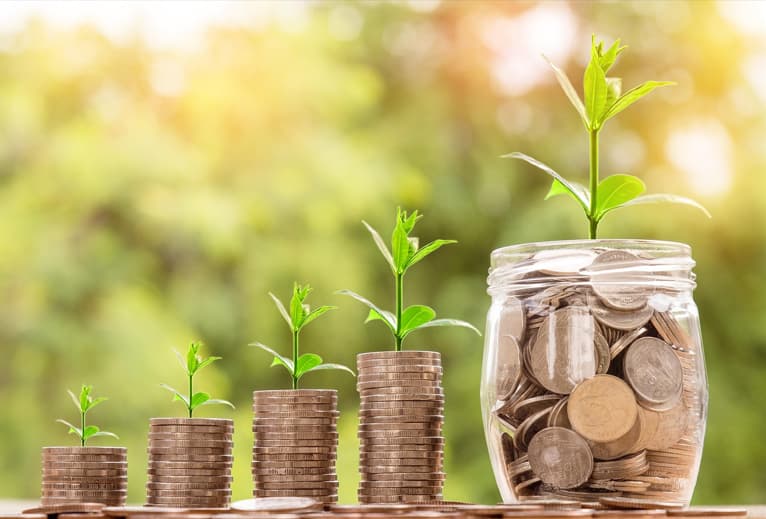 Money jars and coin stacks with green sprouts representing smart money saving strategies in 2025Save money 2025